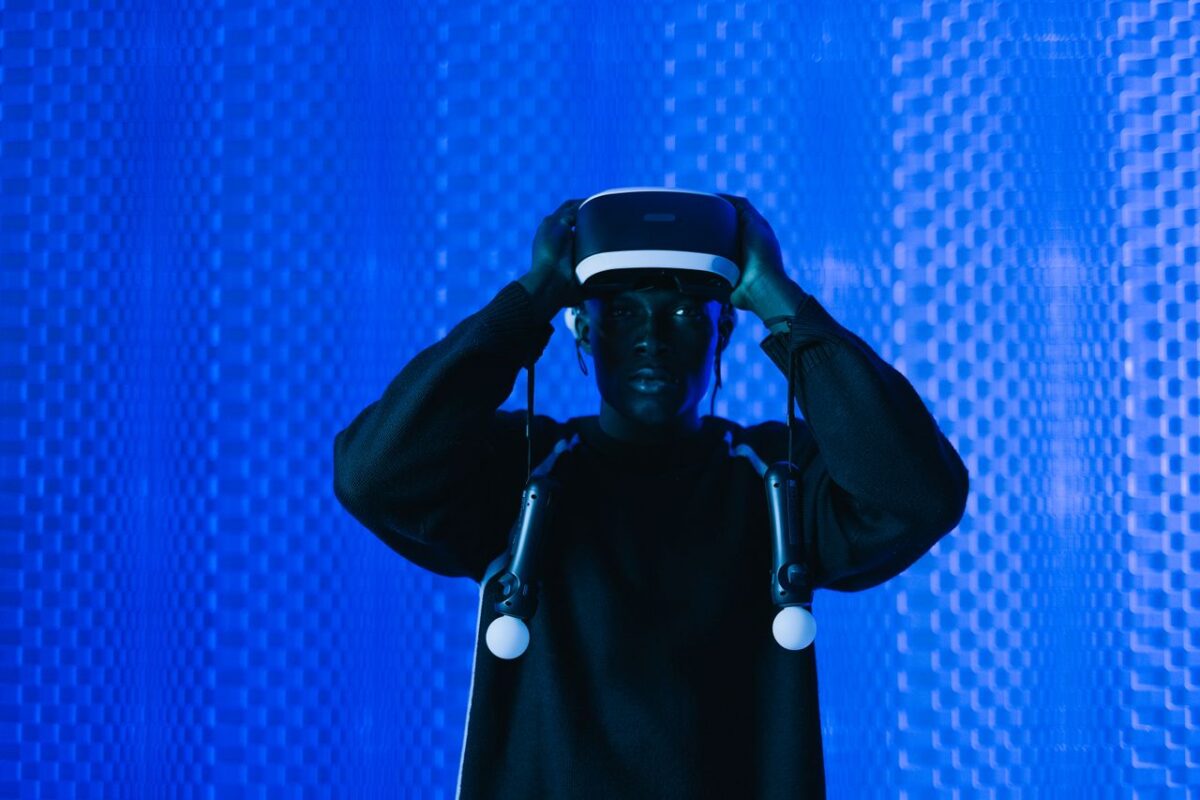 Man immersed in virtual reality using VR headset in a dynamic blue setting.